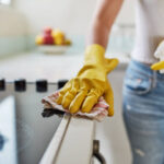 Cropped shot of a woman cleaning a kitchen counter at home